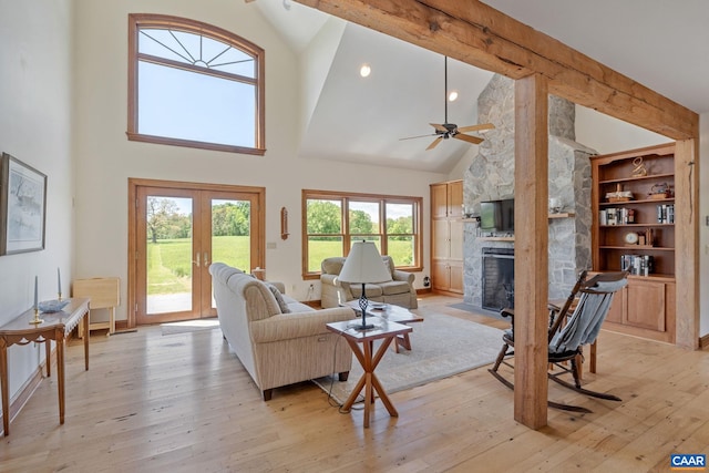 6670 Scottsville Rd, Scottsville, VA 24590 - living room featuring high vaulted ceiling, light wood-type flooring, a fireplace, ceiling fan, and french doors