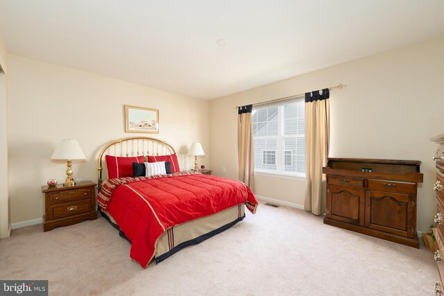 bedroom with light carpet and baseboards