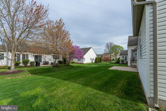 view of green lawn featuring a residential view and a patio area