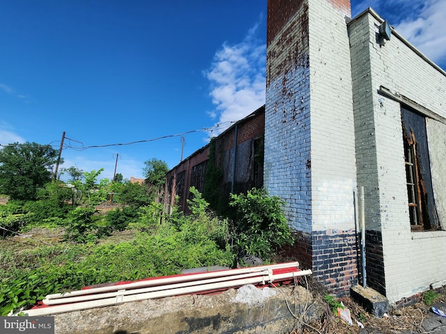 2127 Edmondson Ave, Baltimore, MD 21223 - view of home's exterior featuring brick siding, a chimney, and fence