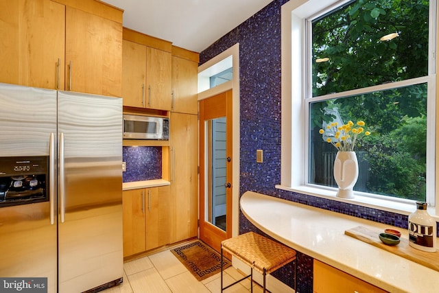 kitchen with appliances with stainless steel finishes, light countertops, and light tile patterned flooring