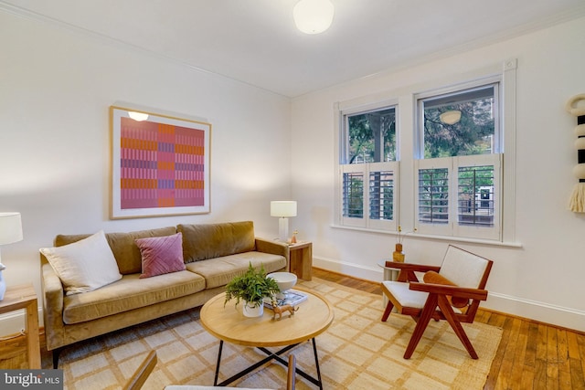 living room with baseboards, crown molding, and wood finished floors