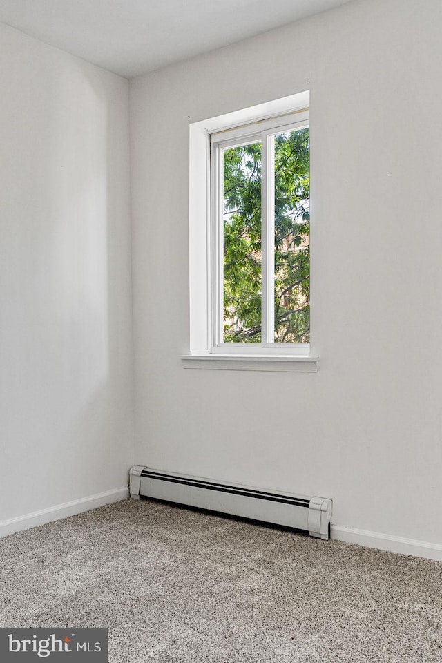 unfurnished room featuring a baseboard heating unit, carpet flooring, and baseboards