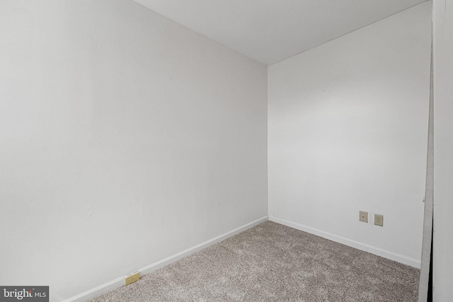 spare room featuring carpet flooring and baseboards