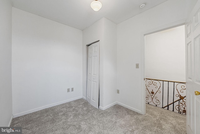 carpeted empty room featuring baseboards