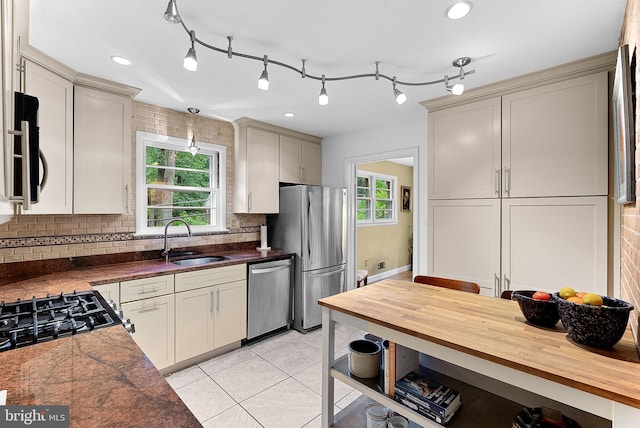 3608 Whispering Ln, Falls Church, VA 22041 - kitchen with a sink, stainless steel appliances, butcher block counters, backsplash, and light tile patterned floors