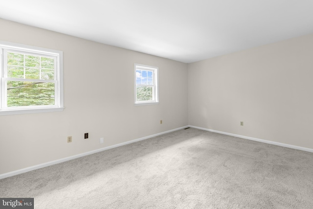 empty room featuring carpet flooring and baseboards