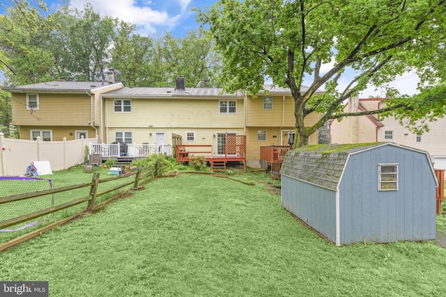 back of property with a shed, an outdoor structure, and a deck