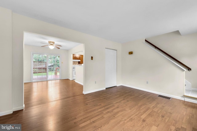unfurnished living room featuring wood finished floors, ceiling fan, and baseboards
