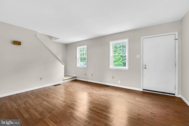 unfurnished living room featuring wood finished floors and baseboards