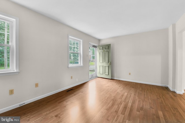 spare room featuring wood finished floors and baseboards