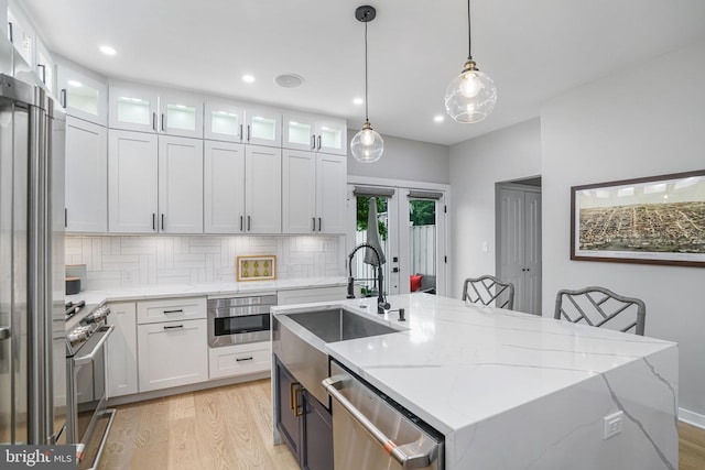603 N Alfred St, Alexandria, VA 22314 - kitchen featuring stainless steel appliances, a sink, white cabinetry, light wood-style floors, and recessed lighting