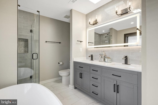 603 N Alfred St, Alexandria, VA 22314 - bathroom featuring marble look tiles, double vanity, a freestanding bath, a stall shower, and toilet