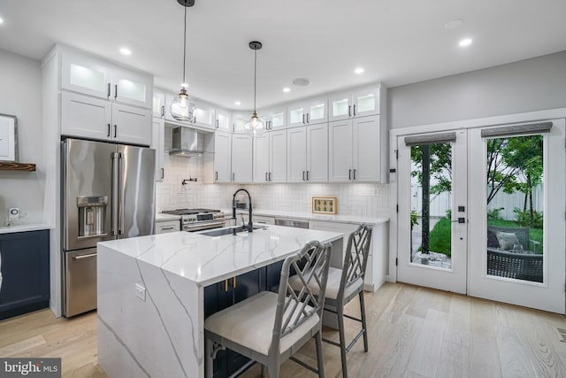 603 N Alfred St, Alexandria, VA 22314 - kitchen with high quality appliances, a sink, wall chimney range hood, light wood-type flooring, and french doors