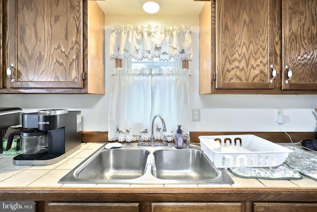 kitchen featuring a sink and tile countertops