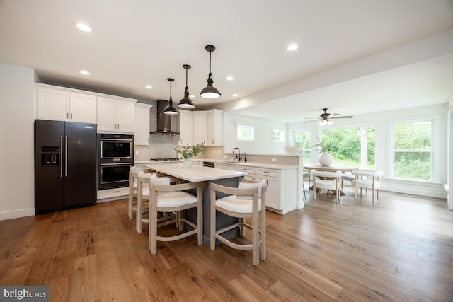 1051 Glen Hall Rd, Kennett Square, PA 19348 - kitchen with black fridge with ice dispenser, a sink, wall chimney range hood, multiple ovens, and light countertops