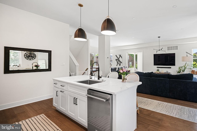 kitchen with a sink, stainless steel dishwasher, open floor plan, light stone counters, and white cabinets