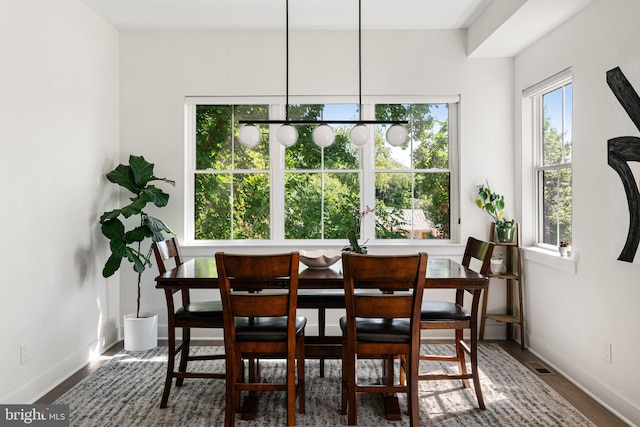 dining area with baseboards and wood finished floors