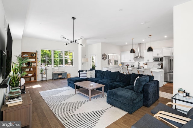 living area with wood finished floors, a chandelier, and recessed lighting