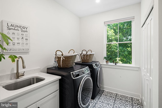 laundry room featuring independent washer and dryer, cabinet space, and baseboards