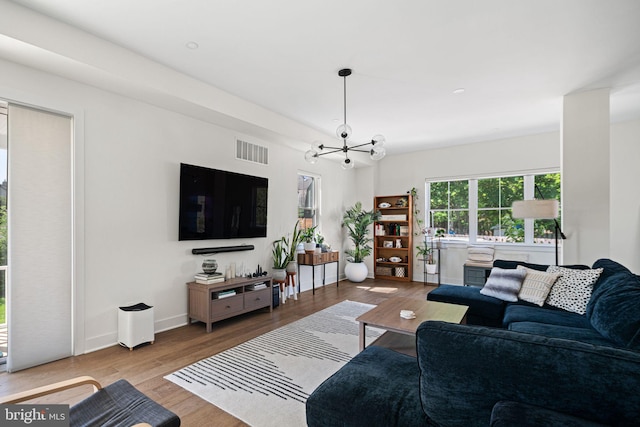 living room with wood finished floors, a chandelier, and baseboards