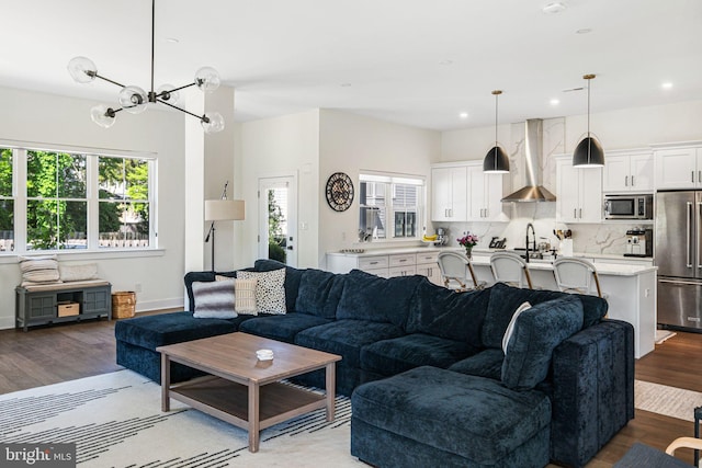 living room featuring a chandelier, wood finished floors, recessed lighting, and baseboards
