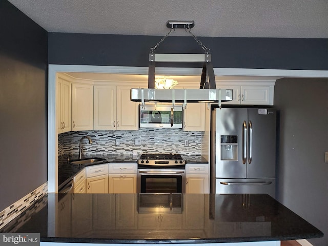 100 W Ave Unit 406S, Jenkintown, PA 19046 - kitchen with stainless steel appliances, a sink, backsplash, a textured ceiling, and dark stone countertops