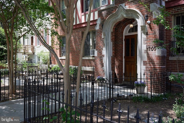 property entrance with brick siding and fence