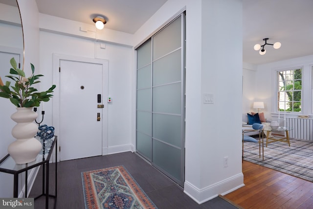foyer entrance featuring dark wood-type flooring and baseboards