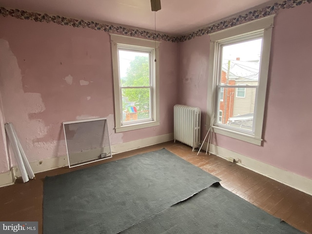 spare room featuring radiator heating unit, baseboards, and ceiling fan