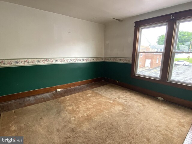 spare room with carpet and baseboards