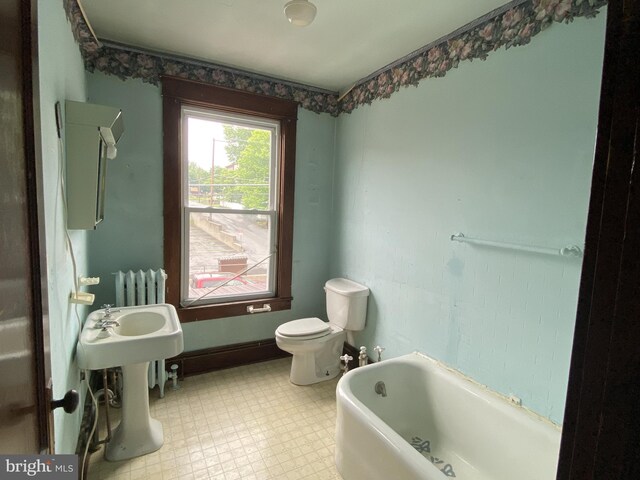 full bath featuring radiator, tile patterned floors, a tub to relax in, and toilet