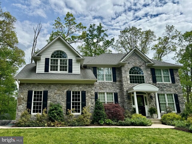 1490 Jakes Creek Dr, Woodbine, MD 21797 - view of front of home with stone siding, a front yard, and roof with shingles