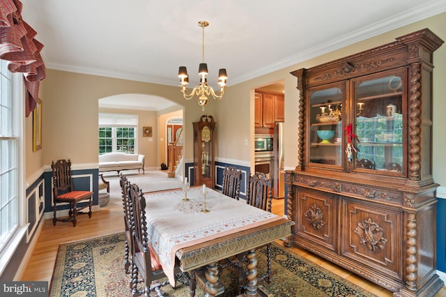 1490 Jakes Creek Dr, Woodbine, MD 21797 - dining area featuring arched walkways, ornamental molding, light wood-style flooring, and a chandelier