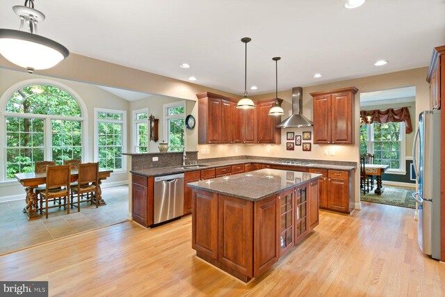 1490 Jakes Creek Dr, Woodbine, MD 21797 - kitchen featuring stainless steel appliances, wall chimney exhaust hood, a sink, brown cabinets, and dark stone countertops