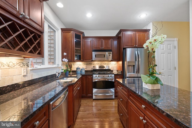 20390 Center Brook Square, Sterling, VA 20165 - kitchen featuring stainless steel appliances, a sink, backsplash, glass insert cabinets, and wood finished floors
