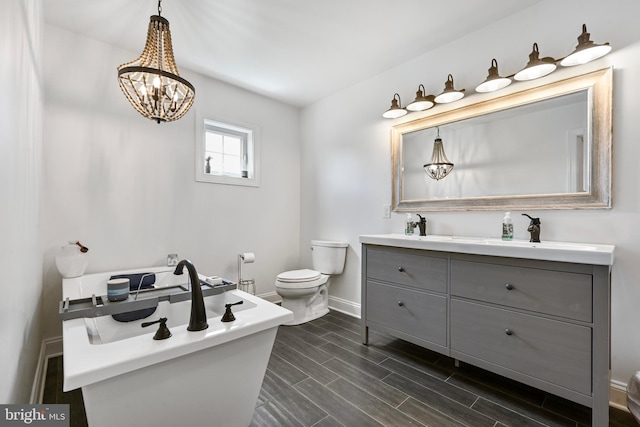 5688 Kirkpatrick Ct, Salisbury, MD 21801 - full bath featuring toilet, double vanity, baseboards, wood tiled floors, and a chandelier