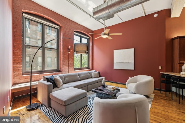 428 N 13th St Unit 3G, Philadelphia, PA 19123 - living room featuring hardwood / wood-style floors, a ceiling fan, brick wall, baseboards, and a towering ceiling