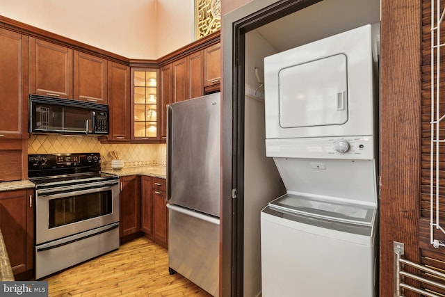 428 N 13th St Unit 3G, Philadelphia, PA 19123 - kitchen featuring stacked washer / drying machine, appliances with stainless steel finishes, light wood finished floors, light stone counters, and tasteful backsplash
