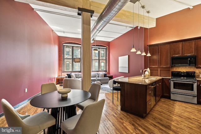 428 N 13th St Unit 3G, Philadelphia, PA 19123 - kitchen with black appliances, a sink, decorative backsplash, light stone counters, and a peninsula