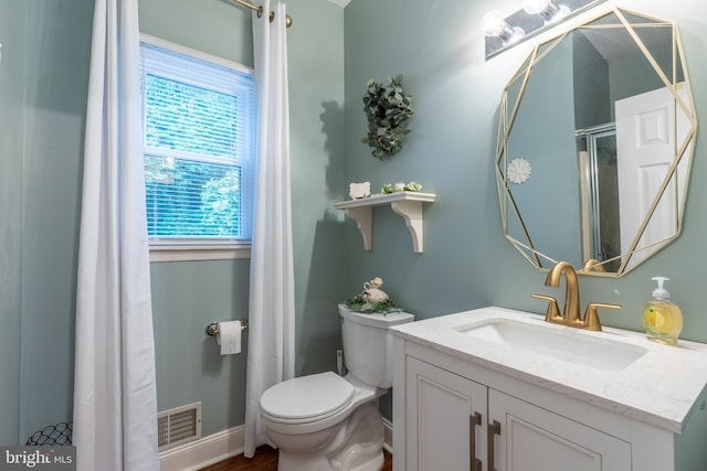 bathroom with toilet, vanity, and baseboards