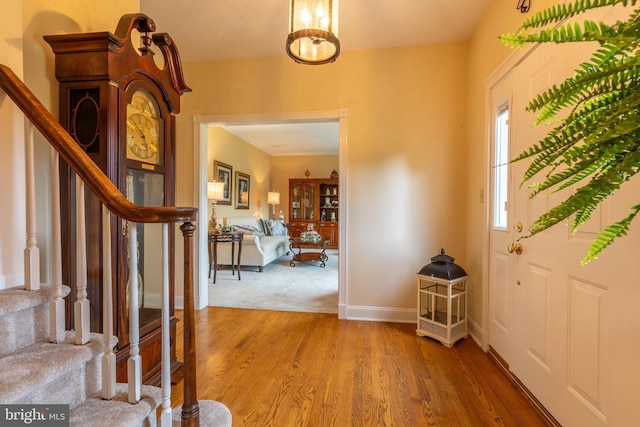 foyer featuring stairway, wood finished floors, and baseboards