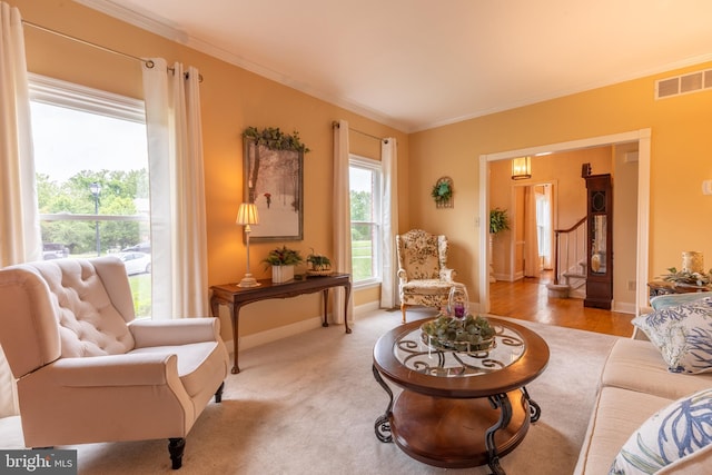 living area with crown molding, baseboards, and stairway