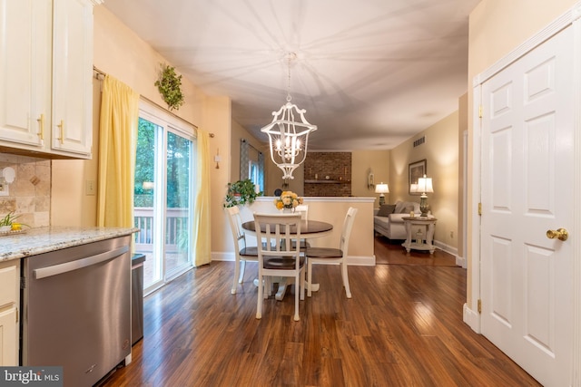 dining space with a chandelier, dark wood-style floors, and baseboards