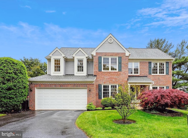 view of front of home featuring driveway, a garage, brick siding, and a front yard