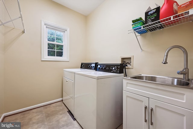 clothes washing area with cabinet space, washer and clothes dryer, baseboards, and light tile patterned floors