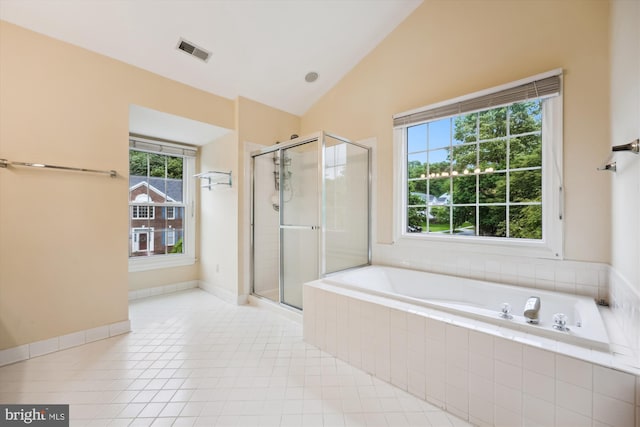 full bath with healthy amount of natural light, vaulted ceiling, a shower stall, and a bath