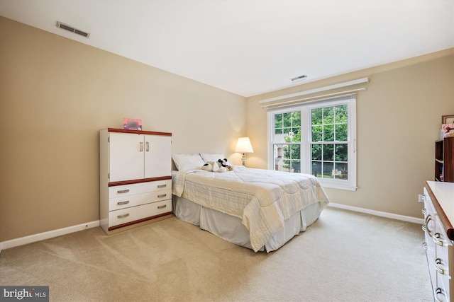 bedroom featuring light colored carpet and baseboards
