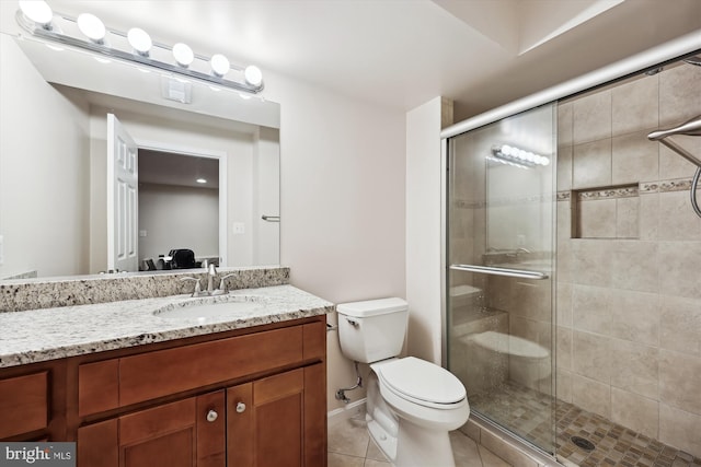 full bath with a stall shower, toilet, tile patterned floors, vanity, and baseboards