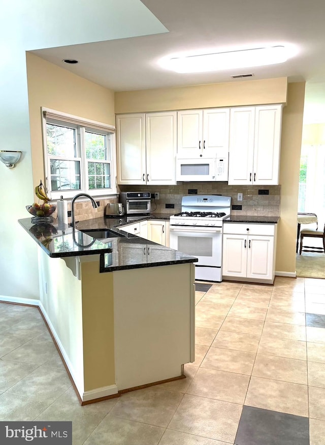 18717 Severn Rd, Gaithersburg, MD 20879 - kitchen featuring white appliances, a sink, backsplash, a peninsula, and white cabinetry